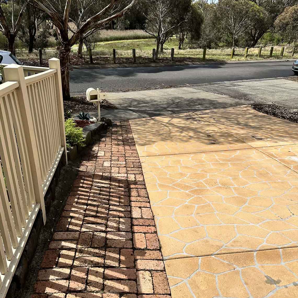 After: clean stamped concrete driveway and brick paving after pressure washing