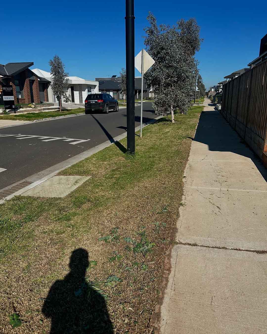 Mown grass nature strip beside a footpath on a suburban street