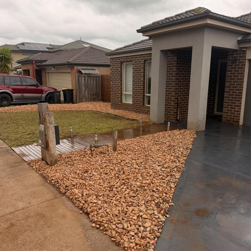 After: front yard cleared of plants, with a new pebble garden bed and lawn